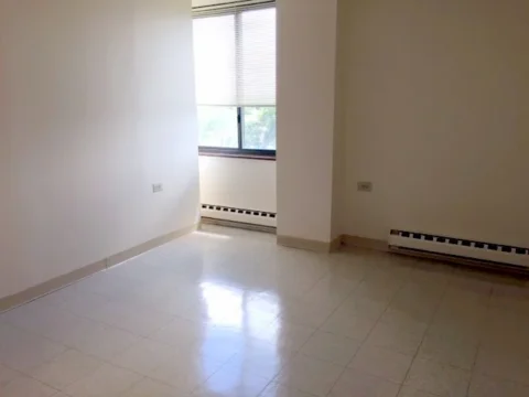 A white living room with linoleum floors.