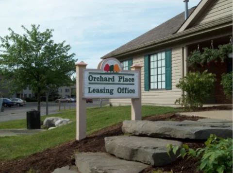 The signage at Orchard Place Leasing Office, with three multi-colored trees above the name.
