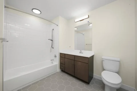 A bathroom with modern sink, shower, and tile work.